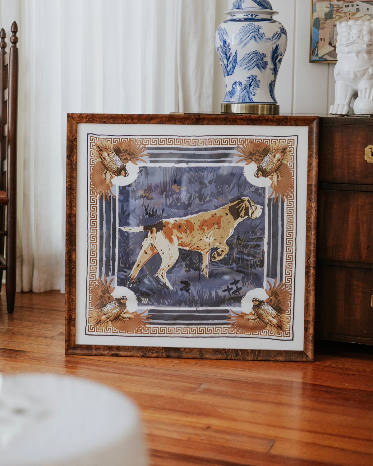 A framed silk scarf featuring a hunting dog illustration with quail