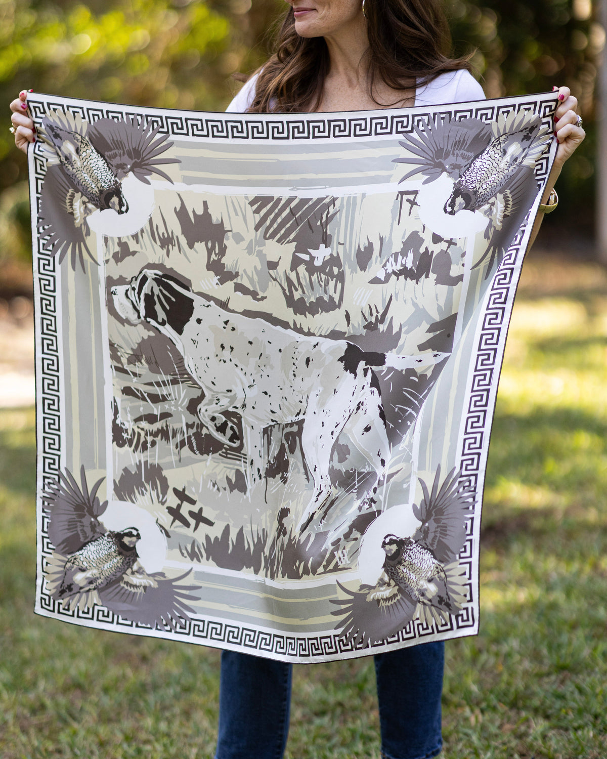 Person holding a large scarf with a neutral bird dog outdoors