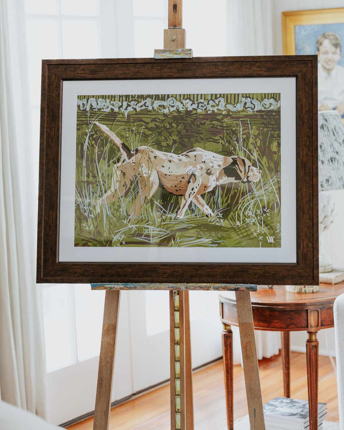 Hunting dog print in olive green with espresso wood frame hanging on an easel.